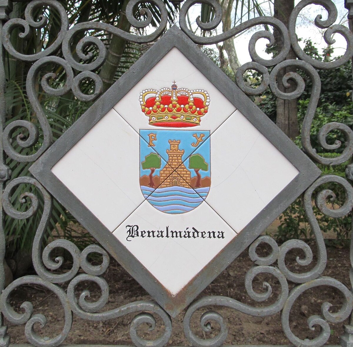 Diamond-shaped sign with crown, castle, and water, featuring "Benalmadena" text.
