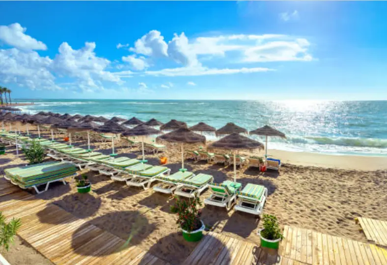 Strand van Benalmádena met ligbedden, parasols en uitzicht op zee